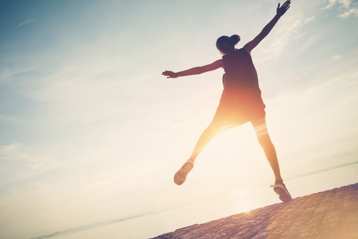 Silhouette of person jumping near ocean